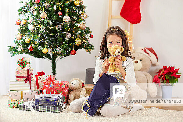Smiling young girl opening Christmas presents