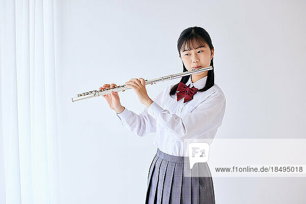 Japanese high school student wearing uniform practicing music