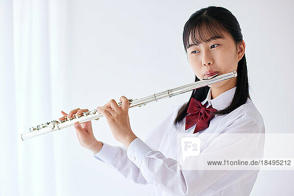 Japanese high school student wearing uniform practicing music