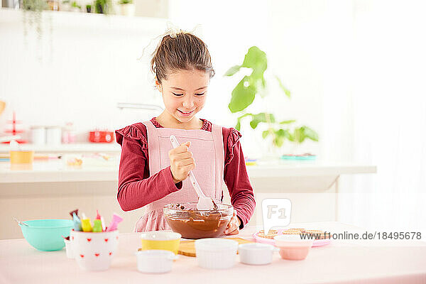 Smiling young girl making sweets