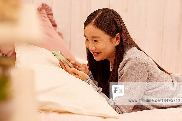 Japanese girl with smartphone in bed