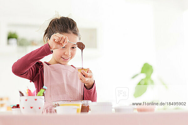 Smiling young girl making sweets