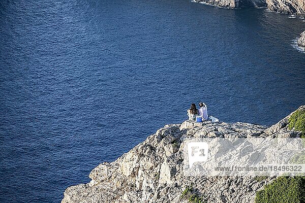 Paar beim Picknick auf einem Felsen  Ausblick auf das Meer  Cap Formentor  Küstenlandschaft  Pollença  Mallorca  Balearen  Spanien  Europa