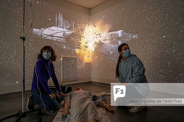 Emergency medicine students attends a circumstantial emergency simulation course led by two emergency physicians. Simulation of a hanging case. A 45-year-old man is found hanged in his home. Images are projected all around the room as well as sound. Students should not let themselves be distracted by these atmospheres and remain focused on their patient.