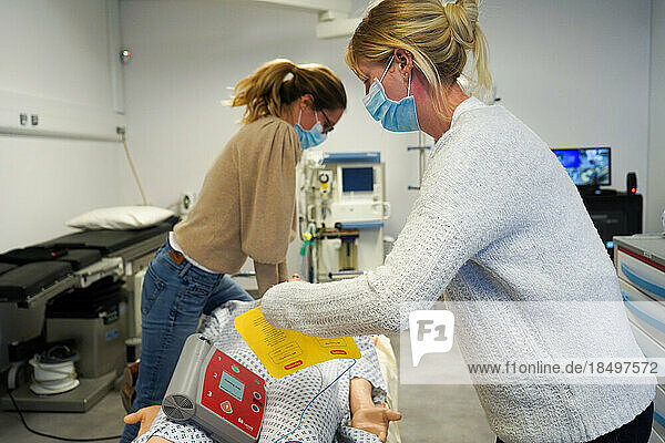 Resuscitation training on a dummy: cardiac massage and defibrillator. Various health professionals are trained in the evolution of practices  care and emergency procedures within the Faculty of Medicine of Montpellier. They must work on serious cases of daily life faithfully reproduced on a SimMan dummy. Here  respiratory arrest on a man in his forties. Attempt to resuscitate using a defibrillator  AED and cardiac massage.