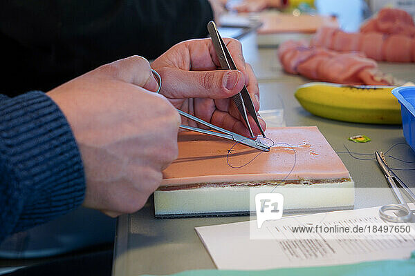 5th year students during a sewing workshop. The students learn the gestures of suturing on false epidermis or bananas.