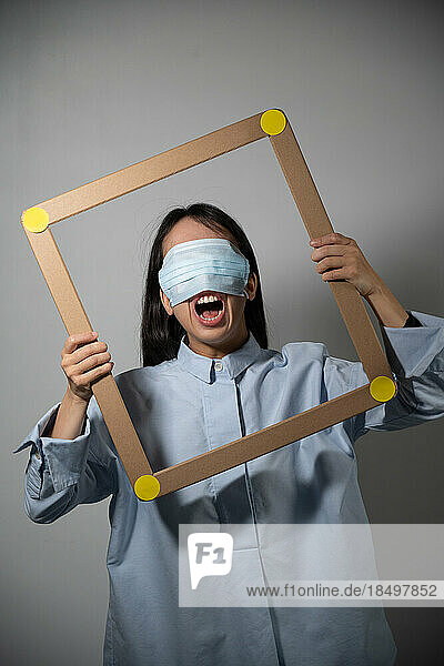 Masked and angry asian young woman