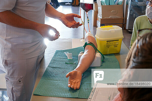 5th year medical students during an IV placement workshop. Students train on an arterial arm allowing arterial and venous puncture for blood sampling. The arm allows work on the Cephalic  basilic  radial and cubital veins as well as the radial and brachial arteries for infusion and blood sampling.
