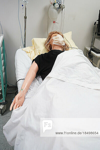 Students facing a post natal emergency follow procedures on a mannequin. This dummy is controlled by operators in an adjoining room. Here  a woman with heavy bleeding following a home birth.