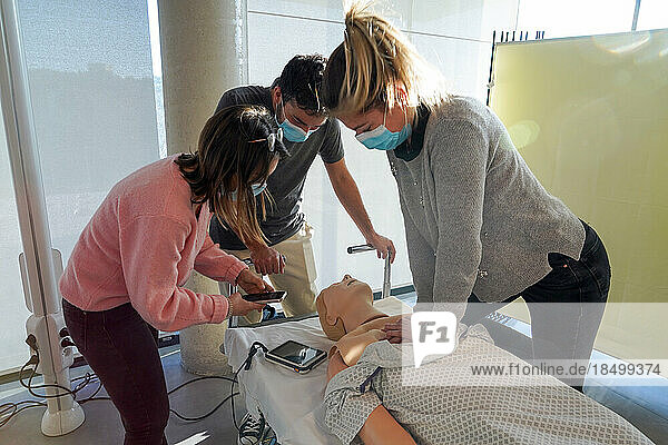 5th year medical students during a SimMan dummy cardiac massage workshop.
