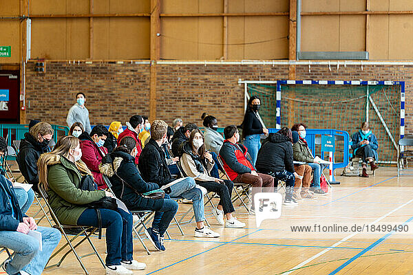 Patients wait in a gymnasium to be vaccinated against Covid.