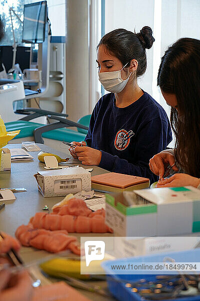 5th year students during a sewing workshop. The students learn the gestures of suturing on false epidermis or bananas.