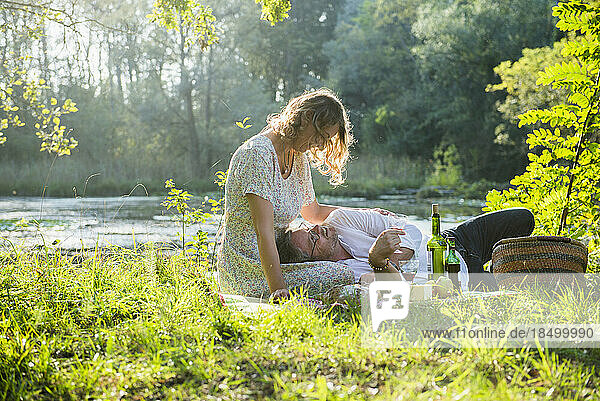 Romantic couple enjoying picnic by lake  Germany