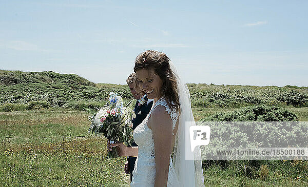 portrait of bride and groom smiling walking on a summers day