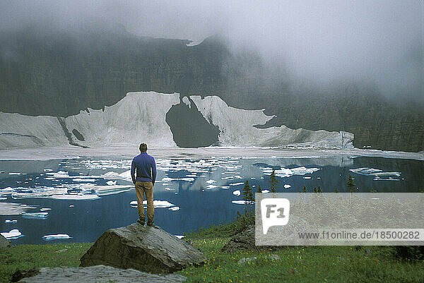 Hiker beside Iceberg Lake. Glacier National Park. Montana.