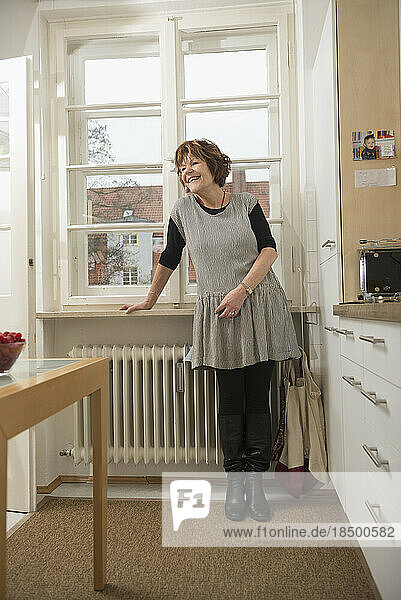 Senior woman standing in the kitchen and smiling  Munich  Bavaria  Germany