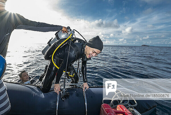 Diver climbing into dinghy after a dive in Banda Sea
