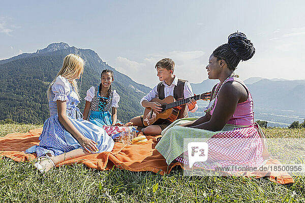 Teenage friends enjoying with guitar during picnic  Bavaria  Germany