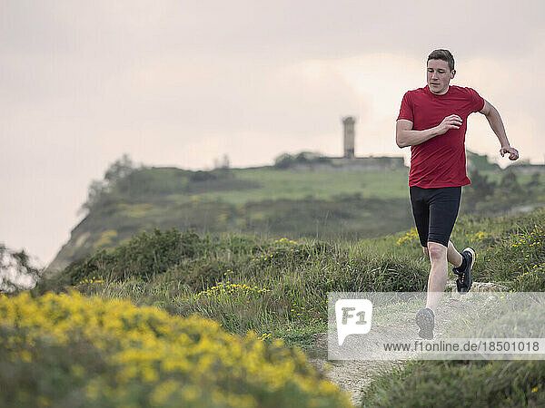 Man trail running on the cliff of Getxo