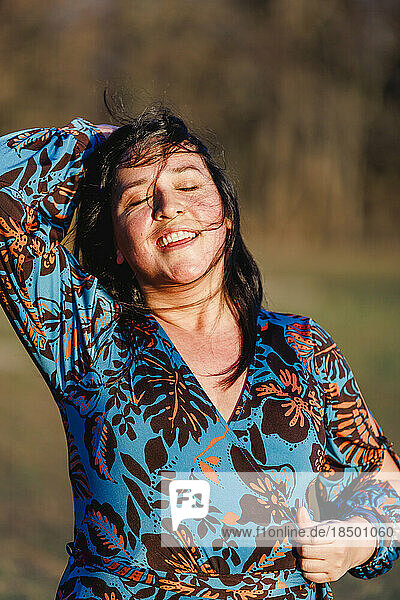 Beautiful  smiling woman with eyes closed in golden light