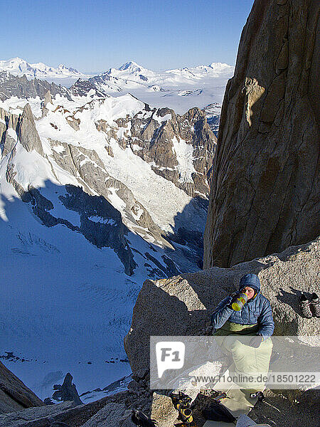 A climber huddles in a sleeping bag during a bivouac on a ledge on the north col of Cerro Fitz Roy  Argentine Patagonia.