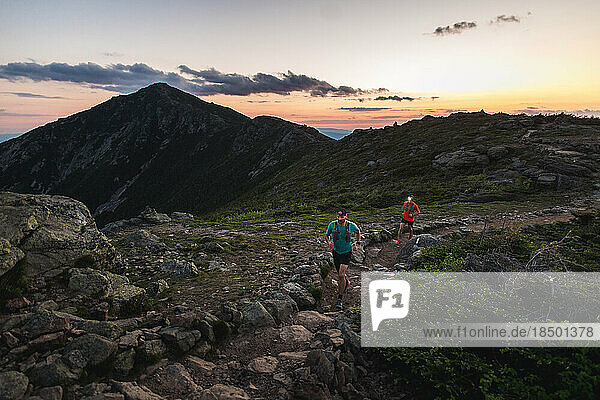 Trail runners running the Franconia Ridge at sunrise