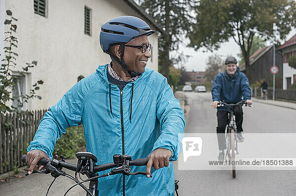 Male friends cycling on road  Bavaria  Germany