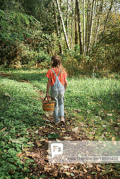 Girl walking in woods with basket