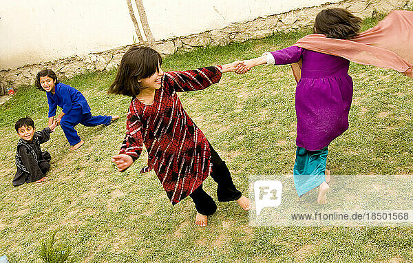 Children laugh and play in the courtyard of their Kabul home.