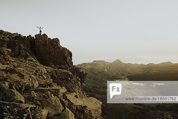 Pulled back of man standing on rock at mountain top in Mount Teide