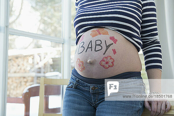 Pregnant woman with drawings on belly