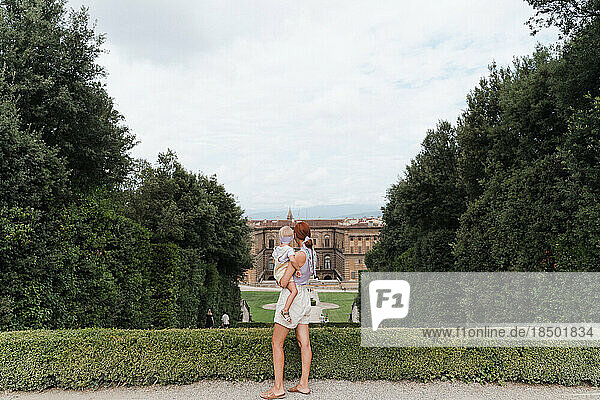 Woman with a toddler in her arms in the Boboli Gardens viewpoint