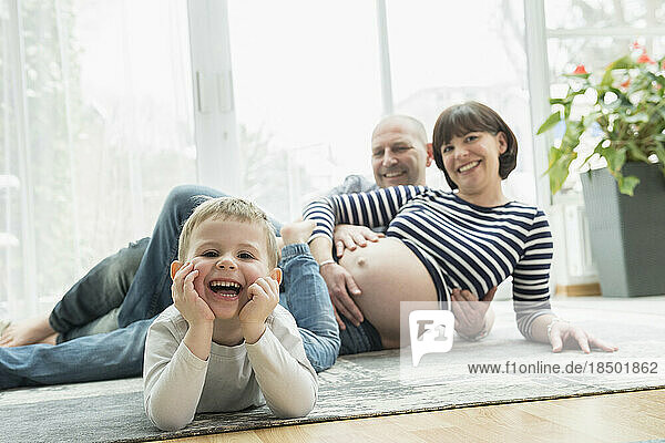 Portrait of family leaning on carpet at home