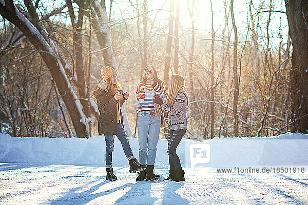 Three happy  beautiful teen girls outdoors in the snow.