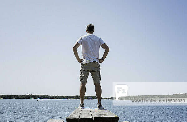 man stood on a bench looking out to sea on vacation