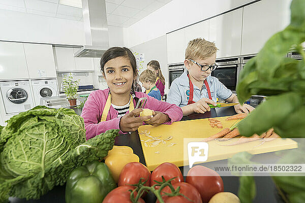 Students peeling and cutting vegetables in home economics class  Bavaria  Germany