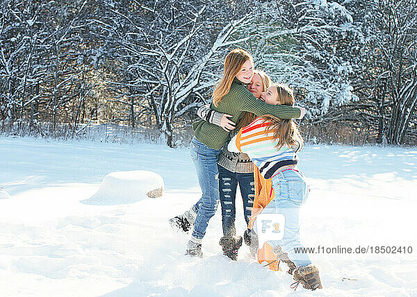 Three tween girls playing in the snow on winter day.