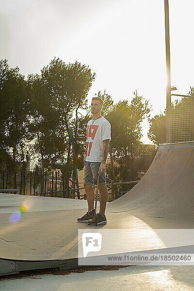 Young man is on a skate court with his skateboard
