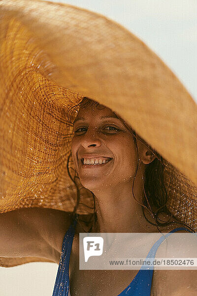 Woman in a straw hat on the ocean. Portrait