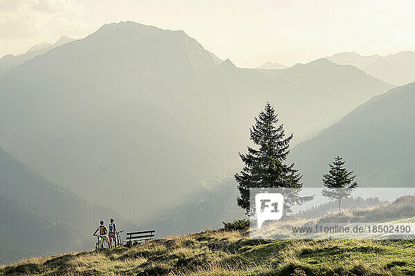 Couple of mountainbikers looking at view in alpine landscape  Zillertal  Tyrol  Austria