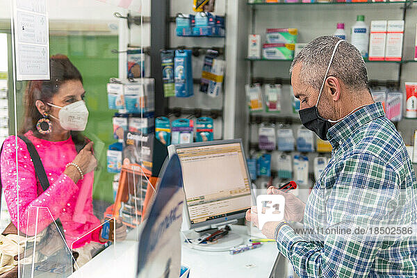 woman buying in a pharmacy  man selling the products