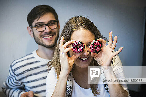 Woman looking through doughnuts while husband watches  Munich  Germany