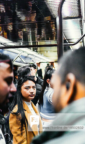 asian girl in the subway surrounded by people