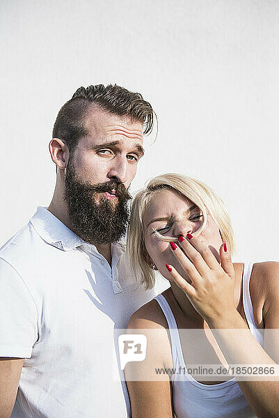 Young man with his playful girlfriend making moustache with hair  Bavaria  Germany