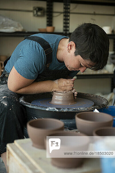 Potter crafting a pot on pottery wheel