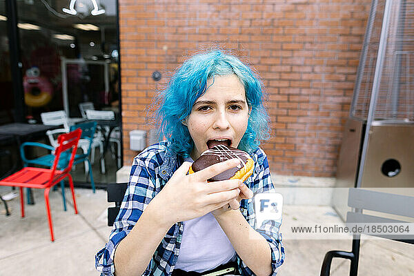 Teen Girl With Blue Hair About To Take A Bite Of A Doughnut