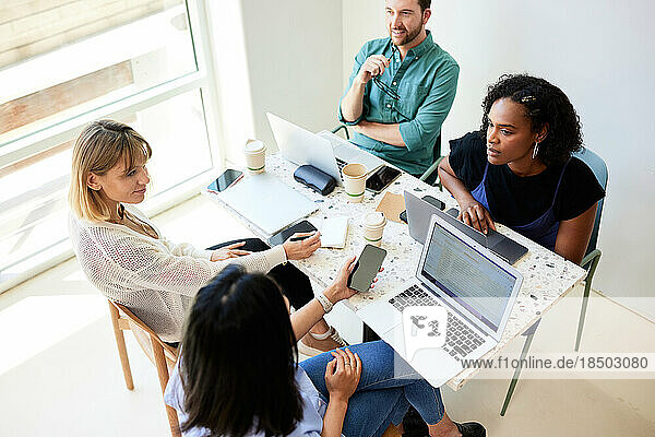 Multiracial colleagues planning business strategy at table in cafe