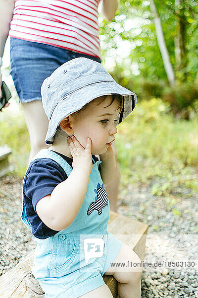 Closeup side view of a young boy wearing a hat in summer
