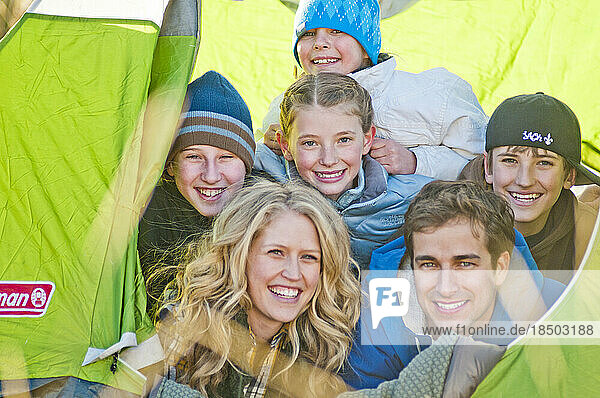 A couple and their kids inside their tent.