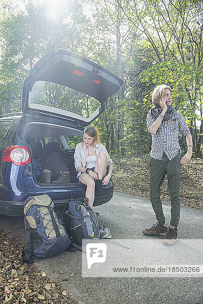 Young couple preparing for hiking in a forest  Bavaria  Germany